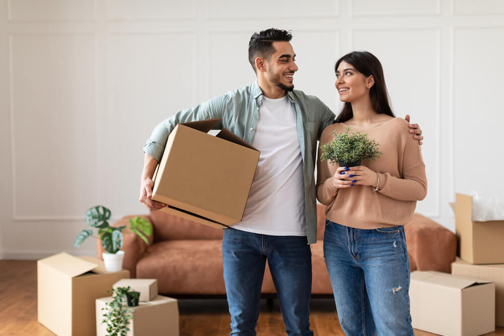 Young couple moving into their first apartment - best renters insurance.